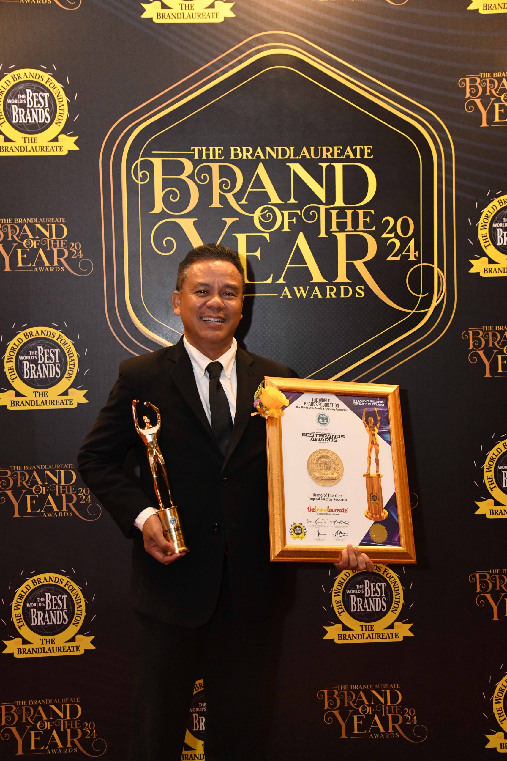 Ismail posing with the trophy and award certificate.